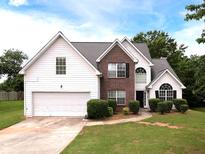 Charming two-story home featuring a brick facade, white siding, and well-manicured landscaping at 148 Barrington Pkwy, Stockbridge, GA 30281