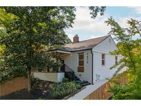 Charming white brick home featuring a covered porch, landscaped yard, and modern architectural details at 1272 Hardee Ne St, Atlanta, GA 30307