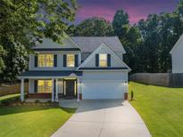 Charming two-story home featuring a well-manicured lawn and a classic architectural design at 5195 Oaks Landing Ct, Sugar Hill, GA 30518