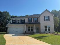 Charming two-story home featuring a two-car garage, light brick facade, and a well-manicured front lawn at 5305 Birch Valley Rd, Cumming, GA 30028