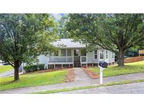 Charming single-story home with a front porch and mature trees in a residential neighborhood at 536 Cherokee Overlook Court Ct, Canton, GA 30115