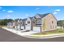 A row of new townhomes featuring attached garages, modern exteriors, and well-maintained landscaping at 215 Silver Moon Dr, Loganville, GA 30052