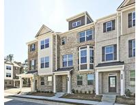 Modern townhome showcases a brick facade, large windows, and covered front entry at 541 Fundao Ln, Lawrenceville, GA 30046