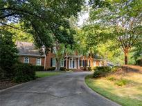 Charming two-story brick home featuring mature landscaping and a winding driveway at 6203 Crestview Drive Southeast Se Dr, Covington, GA 30014
