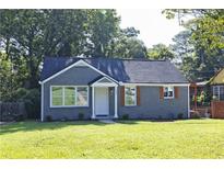 Charming renovated home with gray brick facade and manicured lawn at 672 Quillian Ave, Decatur, GA 30032