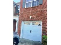 Attached garage with arched entry and carriage style door matches the red brick home's exterior at 1870 Garbrooke, Lawrenceville, GA 30046