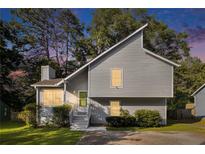 Charming home featuring unique architectural design, green door and landscaped yard at sunset at 1077 Mainstreet Valley Dr, Stone Mountain, GA 30088