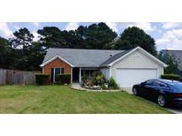 Charming single-story home with a well-manicured lawn, a screened porch, and an attached two-car garage at 20 Bacchus Dr, Lawrenceville, GA 30045