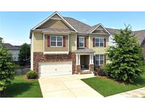 Charming two-story home with stone accents, a well-manicured lawn, and a two-car garage at 253 Orchard Trl, Holly Springs, GA 30115