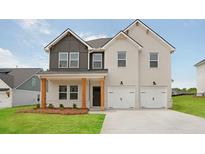 Charming two-story home boasts a painted brick facade, complemented by a two-car garage and a well-manicured lawn at 342 Orwell Drive Lot 95, Social Circle, GA 30025