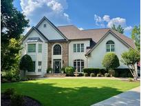 Inviting traditional two-story home featuring a manicured lawn, architectural design, and a charming front entrance at 5085 Johns Creek Ct, Johns Creek, GA 30022