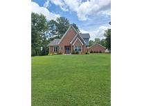 Charming brick home with a well-manicured lawn and mature trees in a peaceful setting at , Stockbridge, GA 30281