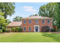 Charming brick home featuring a manicured lawn and traditional architectural details at 3794 Brown Owl Ct, Marietta, GA 30062