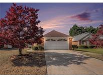 Charming brick home featuring a spacious driveway and a well-maintained front yard, accented by a beautiful red tree at 3264 Salem Cove Se Trl, Conyers, GA 30013