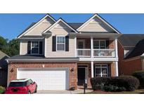 Charming two-story home with brick accents, neutral siding, a two-car garage, and a cozy front porch at 2435 Hickory Station Cir, Snellville, GA 30078