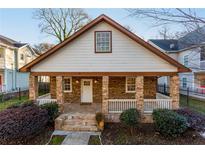 Charming home featuring a stone facade, covered porch with stone pillars, and manicured landscaping at 83 Ormond Se St, Atlanta, GA 30315