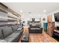 Open-concept living room boasts hardwood floors, shiplap accent wall, and seamless flow into modern kitchen at 2110 Augusta Se Dr # 204, Marietta, GA 30067