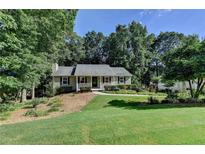 Charming one-story home featuring a well-manicured lawn and mature trees at 1990 Holly Cove Rd, Cumming, GA 30040