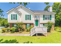 Charming two-story home featuring a well-manicured lawn, green shutters, and a cozy front porch at 2325 Sailor Ln, Suwanee, GA 30024