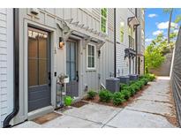 Charming townhome exterior with pergola, lush landscaping, and sidewalk at 12 Becker Nw Pl, Atlanta, GA 30307