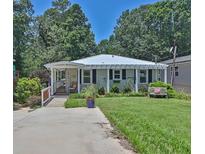 Charming single-story home with a well-manicured lawn, inviting front porch, and a cozy bench at 3131 Lee Cir, Buford, GA 30518