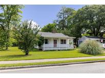 Charming one-story home with a front porch and well-maintained lawn surrounded by mature trees at 849 N Park Ave, Marietta, GA 30060