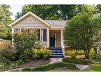 Charming home featuring a stone walkway, blue stairs, and a beautifully landscaped front yard with mature trees at 2732 Arbor Se Ave, Atlanta, GA 30317