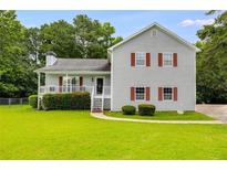 Charming two-story home with a well-manicured lawn, inviting curb appeal and a covered front porch at 1876 Kathy Ct, Douglasville, GA 30135