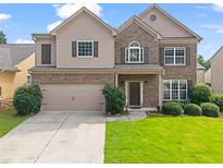 Charming two-story home featuring a well-manicured lawn, a two-car garage, and a welcoming front porch at 1786 Jameson Cir, Lawrenceville, GA 30043