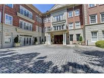 Brick building with stone accents, balconies, and a cobblestone entrance at 5415 Northland Ne Dr # 303, Atlanta, GA 30342