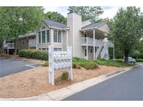 Exterior of a two-story home with off white siding, a chimney, landscaping, and mailboxes out front at 1910 Countryside Se Pl, Smyrna, GA 30080