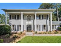 Stately two-story home with gray brick, black shutters, and prominent white columns at 6300 Blackwater Trl, Atlanta, GA 30328