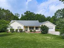 Charming single-story home featuring a well-manicured front yard and attached garage at 10307 E Cherokee Dr, Canton, GA 30115