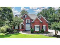 Beautiful two-story brick home with manicured lawn and mature trees at 6010 Somerset Ct, Suwanee, GA 30024