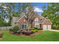 Charming two-story brick home with a well-manicured lawn and mature landscaping at 2720 Stillwater Lake Ln, Marietta, GA 30066