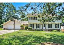 Two-story home with a well-manicured lawn, black shutters, a basketball hoop, and an attached two-car garage at 5419 Ahyoka Dr, Morrow, GA 30260