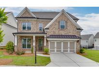 Charming brick two-story home featuring a two-car garage, landscaped lawn, and covered front porch entrance at 1459 Bennett Creek Ovlk, Suwanee, GA 30024