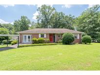 Charming brick ranch-style home with a well-manicured lawn and mature trees at 2880 Sherwood Se Rd, Smyrna, GA 30082