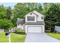Charming two-story home featuring a well-manicured lawn, inviting entryway, and a two-car garage at 1029 Megan Ct, Sugar Hill, GA 30518