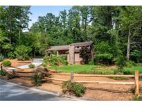 Charming two-story home with a well-manicured lawn, mature trees and a rustic wooden fence at 3152 Sycamore Ln, Marietta, GA 30066