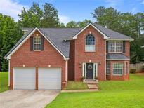 Charming brick home with a well-manicured lawn and a two-car garage at 5841 Cobalt Dr, Powder Springs, GA 30127