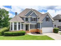 Stunning two-story home with beautiful blue siding, stone accents, manicured lawn, and a two-car garage at 2875 Daniel Park Run, Dacula, GA 30019