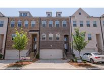 Charming brick townhome with a two-car garage and well-maintained landscaping in a private residence at 2247 Pink Hawthorn Dr, Buford, GA 30518