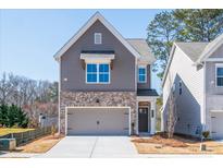 Charming two-story home with brick accents, a two-car garage, and manicured front lawn on a sunny day at 304 Marigold Ln, Woodstock, GA 30188