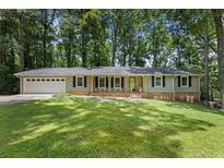 Charming one-story home featuring a well-manicured lawn and an attached two-car garage at 3957 Evans Drive Dr, Lithia Springs, GA 30122