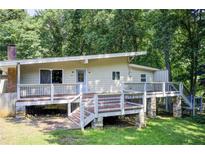 Charming home featuring an elevated deck and a serene, wooded backdrop at 504 N Little Victoria Rd, Woodstock, GA 30189