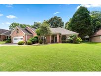 Charming single-story brick home featuring an attached garage, mature trees, and a well-manicured lawn at 1297 Hadaway Trl, Lawrenceville, GA 30043