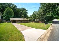 Charming single-story home with a long driveway and well-manicured lawn at 3464 Navaho Se Trl, Smyrna, GA 30080