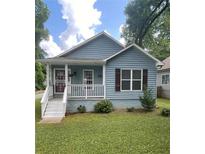 Charming blue house featuring a cozy front porch and well-maintained lawn at 1833 Phillips Ave, East Point, GA 30344
