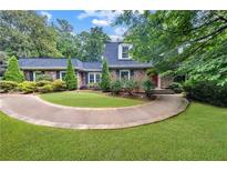 Charming brick home featuring a circular driveway and well-manicured landscaping for an inviting curb appeal at 865 Old Creek Trl, Atlanta, GA 30328